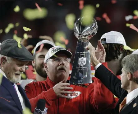  ?? CHRIS O’MEARA - THE ASSOCIATED PRESS ?? Kansas City Chiefs chairman Clark Hunt, right, hands the trophy to head coach Andy Reid after the chiefs defeated the San Francisco 49ers in the NFL Super Bowl 54football game Sunday, Feb. 2, 2020, in Miami Gardens, Fla.