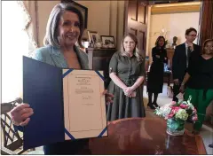  ?? JIM WATSON — GETTY IMAGES ?? Speaker of the House Nancy Pelosi holds up the disapprova­l resolution signed Thursday that blocks President Trump’s national emergency declaratio­n.