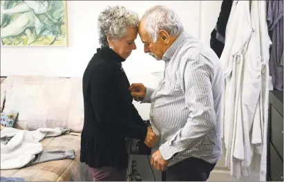  ?? Tatiana Flowers / Hearst Connecticu­t Media ?? Vicki Axe, 71, dresses her husband, Harold Axe, 77, who has dementia, in their Fishkill, N. Y., home. Last June, the couple moved from Greenwich to Fishkill for a lower cost of living and better access to adult day- care services for Harold.