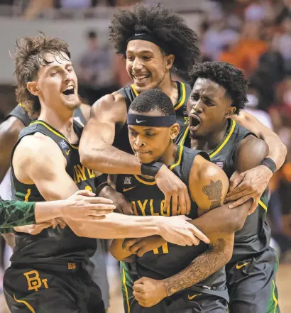  ?? ROB FERGUSON/USA TODAY SPORTS ?? Baylor teammates celebrate with guard James Akinjo (11), whose pull-up jumper won the game against Oklahoma State.