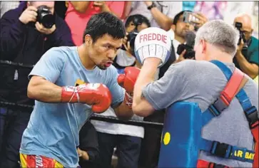  ?? Frederic J. Brown AFP/Getty Images ?? MANNY PACQUIAO, sparring with Freddie Roach, isn’t worried Keith Thurman will have a size advantage.