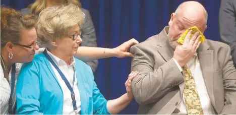  ?? RICK KINTZEL/THE MORNING CALL ?? Former priest James Faluszczak, who says he was molested by a priest as a teenager, wipes away tears while others such as Juliann Bortz, another victim of priest sexual abuse, support him last August when Pennsylvan­ia Attorney General Josh Shapiro released a grand jury report that went into detail about abuse in the church.