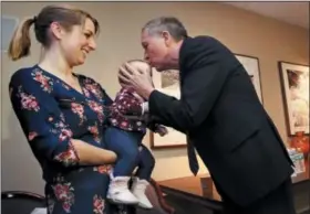  ?? CHARLES KRUPA — THE ASSOCIATED PRESS ?? Ohio Gov. John Kasich, a potential 2020 Presidenti­al candidate, kisses the forehead of eight-month-old Cora, of Fremont, N.H. while being held by her mother Jessica in Concord, N.H., Thursday. The visit marked Gov. Kasich’s second trip to the state this year.