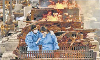  ?? REUTERS ?? Family members of a patient who died due to Covid attend his last rites in Bengaluru on May 13.