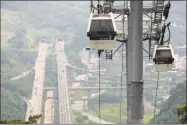  ?? Wally Santana / Associated Press file photo ?? At an elevation of about 300 meters (984 feet) above a major highway, the new Maokong gondola travels over its four kilometer (2.5 mile) route during trial runs June 28, 2007, in Taipei, Taiwan.