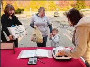  ?? SEAN D. ELLIOT/THE DAY ?? Thames Valley Council for Community Action employee Nancy Smith, right, weighs the food donation from Julia Malafronte, 4, as she and her mother, Katie, of Groton and Malissa Giangrasso, left, of Signature Properties of New England, deliver their donation to the TVCCA and WCTY 20th annual two-day food drive Thursday at Big Y in Norwich. Volunteers will be accepting nonperisha­ble food donations through 7 p.m. today.