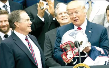  ?? SAUL LOEB/AFP ?? US President Donald Trump holds a football helmet given to him by New England Patriots head coach Bill Belichick (left) alongside members of the team during a ceremony honouring them as 2017 Super Bowl Champions on April 19.