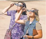  ?? TREVOR HUGHES, USA TODAY ?? Carrie Trochim, 34, left, and Kirsten Polley, 26, test out eclipse glasses in Boulder, Colo.