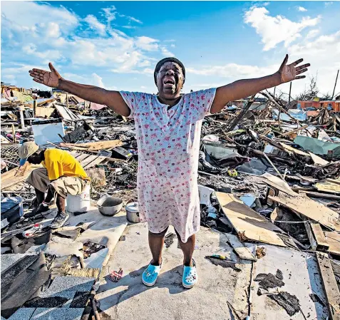  ??  ?? Aliana Alexis stands on a concrete slab of what is left of her storm ravaged home after Hurricane Dorian devastated Great Abaco Island, the worst affected area of the Bahamas