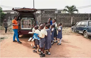  ?? — AFP ?? Book club: Illori (left) talking to the children from Bethel Nursery and Primary School about the importance of reading in Lagos.