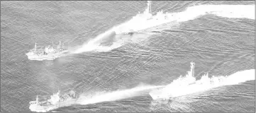  ?? — Reuters photo ?? An aerial view shows Japan Coast Guard patrol vessels spraying water at fishing boats from North Korea, in an area called the Yamato Shallows, where in waters Japan says is part of its exclusive economic zone (EEZ) in this handout photo taken in...