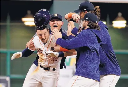  ?? MATT SLOCUM/ASSOCIATED PRESS ?? Albuquerqu­e’s Alex Bregman, left, is mobbed after he drives in the winning run in the bottom of the 10th inning of Game 5 of the World Series. Bregman had two hits and scored two runs in Houston’s 13-12 victory.