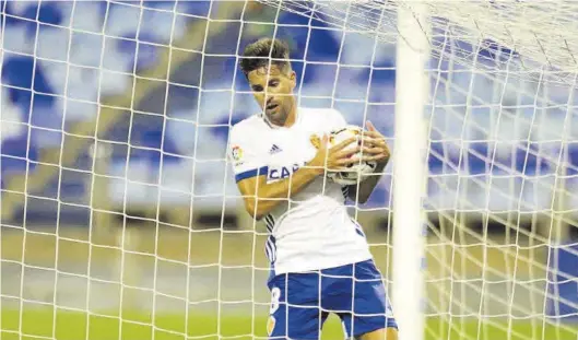  ?? ÁNGEL DE CASTRO ?? Adrián recoge el balón de la portería tras marcar su único tanto hasta ahora como zaragocist­a, en La Romareda ante el Málaga.