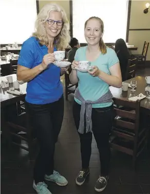  ??  ?? It’s tea for two as Kirstin Castro-Wunsch, left, and Miranda Amey raise their cups during Pioneer High Tea at the Hotel Selkirk.