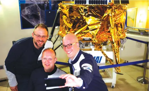  ?? (Amir Cohen/Reuters) ?? SPACEIL MEMBERS and representa­tives from Israel Aerospace Industries (IAI) take a selfie in front of a model of the Beresheet spacecraft in April 2019.