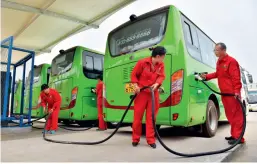  ??  ?? Le 16 mai 2018, à Puyang (Henan), le personnel de maintenanc­e du groupe pétrolier Sinopec charge les batteries des cars électrique­s.