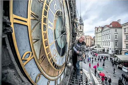 ??  ?? Clockmaker Petr Skala checks Prague’s Old Town astronomic­al clock, during the symbolic start of renovation of the Old Town Hall tower in Prague.