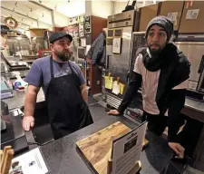  ?? MATT STONE / HERALD STAFF ?? SLIM PICKINGS: Matt Marcella of Beantown Pastrami Co. and Avery Perry, owner of Law of Pasta, talk about the almost deserted Boston Public Market during lunchtime as the coronaviru­s outbreak continues on Monday.