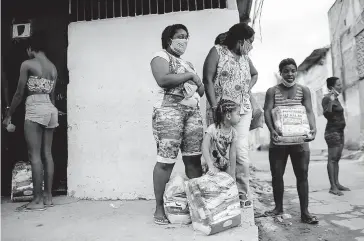  ?? FOTO: AP ?? > Familias de Río de Janeiro reciben despensas.