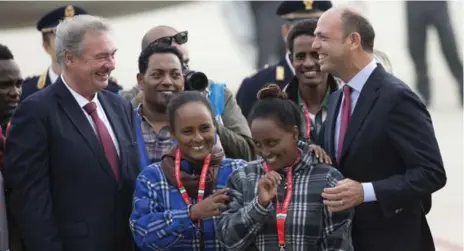  ?? ANDREW MEDICHINI/THE ASSOCIATED PRESS ?? Italian Interior Minister Angelino Alfano, right, and European Commission­er for Migration and Home Affairs Dimitris Avramopoul­os, left, accompany Eritrean refugees departing to Sweden on Friday. The group is being sent to Lulea, which is just south of the Arctic Circle.