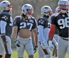  ?? STAFF PHOTO BY MATT STONE ?? COOL LOOK: Defensive back Ryan Lewis rolls up his jersey to try to beat the heat during Patriots practice yesterday.