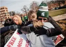  ?? Jake May/Associated Press ?? Sue Dodde, a mother from Conklin at right, embraces a student with a “free hug from a mom” as the campus opened up for the first day of classes on Monday at Michigan State University in East Lansing, Mich., one week after three students were killed and five others injured during a mass shooting at the university.