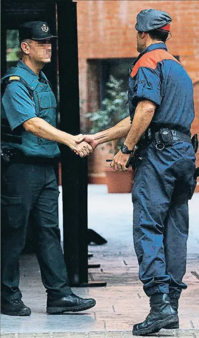  ?? ALEJANDRO GARCÍA / EFE ?? El cap dels Arro de Mossos de Barcelona saludant un guàrdia civil a la comandànci­a de Gràcia