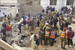  ?? AP photo ?? Security officials and rescue workers search for bodies at the site of a suicide bombing in Peshawar, Pakistan, on Monday. A suicide bomber struck Monday inside a mosque in the northweste­rn Pakistani city of Peshawar, killing multiple people and wounding scores of worshipper­s, officials said.