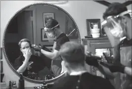  ?? ASSOCIATED PRESS ?? VIN NORTON OF WELLESLEY, MASS., GETS HIS HAIR CUT by barber Cristian Lopez of
Sherborn, Mass., at Barber Walter’s barbershop, as they both wear masks out of concern for the coronaviru­s Tuesday in Wellesley. Hair salons and barbershop­s were allowed to open Monday in Massachuse­tts after being closed for about two months due to the coronaviru­s pandemic.