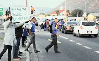  ?? PICTURE: TRACEY ADAMS ?? ENOUGH: A resident holds up a poster urging an end to the violence in Lavender Hill.