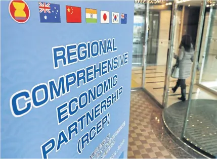  ?? AP ?? A woman walks by the venue hosting the Regional Comprehens­ive Economic Partnershi­p last month in Japan. Asean member countries have agreed to cut tariffs on a wide range of products under the RCEP framework in the coming years.