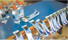  ?? AFP-Yonhap ?? Workers paste labels on the bottles with meltwater of Gangotri glacier which is the primary source of the pious river Ganges at the Indian Post office in Uttarkashi, Sept. 14.