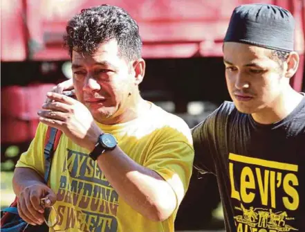  ?? PIC BY MUHAMMAD ASYRAF SAWAL ?? Drowning victim Azfar Mohammad’s father, Mohammad Chek Din (left), 52, being consoled at the Berkelah Recreation­al Forest Waterfall near Kuantan yesterday.