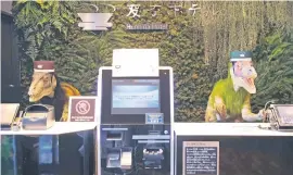  ??  ?? CHECK-IN WITH A DIFFERENCE. A pair of robot dinosaurs wearing bellboy hats welcome guests from the front desk at the Henn na Hotel in Urayasu.
