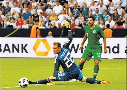  ?? Martin Meissner ?? The Associated Press Germany goalkeeper Marc-andre ter Stegen makes a save in front of Saudi Arabia’s Taisir Al-jassim during a soccer friendly Friday at Bayarena in Leverkusen, Germany. Die Mannschaft, or The Team, won 2-1, in advance of defending...