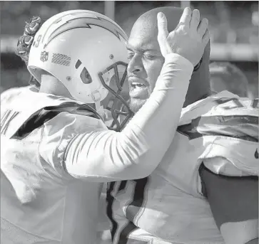  ?? Ben Margot Associated Press ?? CHARGERS KICKER Nick Novak, left, hugs nose tackle Brandon Mebane after kicking a game-winning field goal against Oakland in October. Mebane gives pregame motivation­al speeches to his teammates.