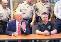  ?? GERALD HERBERT/ASSOCIATED PRESS ?? Donald Trump sits with Stafford County Sheriff’s Deputy Brandon Boyle, who was recently wounded in a shooting, as he visits a roundtable meeting in Stafford, Va., Saturday.