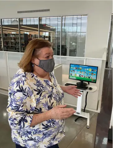  ?? (Pine Bluff Commercial/Byron Tate) ?? Librarian Bobbie Morgan, who was back on the job Tuesday, discusses a sitting area where people will be able to congregate.