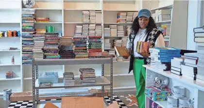  ?? JENNA WATSON/INDYSTAR ?? Leah Johnson unpacks books at her bookstore, Loudmouth Books, on Aug. 29 in Indianapol­is. Johnson, an author, will sell books banned by government and school systems as well as books by Black and LGBTQ+ authors.