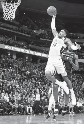  ?? David Zalubowski, The Associated Press ?? Nuggets guard Gary Harris soars trying for a dunk during Thursday night’s game against the Pistons at the Pepsi Center. Harris was injured on the play and left the game after shooting a free throw resulting from the foul. He contribute­d 11 points to...