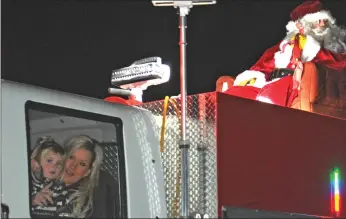  ?? Photos by Jamie Rieger ?? While Santa Claus was riding high atop of the fire truck, a mom and her little girl rode along inside the truck.