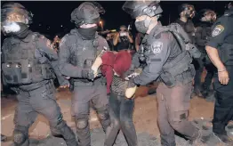  ?? ODED BALILTY/AP ?? Israeli police officers detain a Palestinia­n demonstrat­or Saturday during a protest against the planned evictions of Palestinia­n families in east Jerusalem.