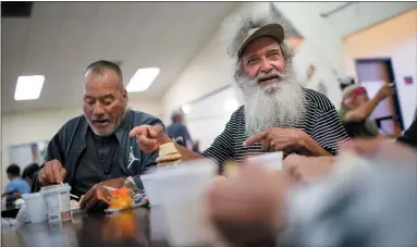  ?? DAI SUGANO — STAFF PHOTOGRAPH­ER ?? Loaves & Fishes Family Kitchen clients Celso Montes, right, and Jesus Castro enjoy a conversati­on during dinner at the Eastside Neighborho­od Center on Alum Rock Avenue in San Jose. The nonprofit provides 1million-plus meals each year at three sites.