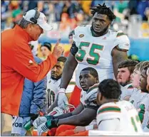  ?? MIAMI HERALD ?? UM offensive line coach Stacy Searels talks with Navaughn Donaldson (55) and other linemen in UM’s loss to Pittsburgh last November. Donaldson is projected to start at right tackle in 2018.