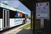  ?? HYOSUB SHIN / HSHIN@AJC.COM ?? Gwinnett County Transit leaves a bus stop at Buford Highway and North Berkeley Lake Road. The county has adopted an ambitious transit developmen­t plan, and a referendum is possible.