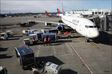  ?? JOHN MOORE — GETTY IMAGES ?? Delta Air Lines is only offering two snacks, giving first class boxed meals and only serving bottled water for beverages on domestic and shorter internatio­nal flights. Its pre-flight lounges, the Sky Club, have been closed due to declining numbers.