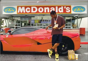  ?? JERRITT CLARK — GETTY IMAGES ?? McDonald’s
Travis Scott surprises crew and customers at McDonald’s for the launch of the Travis Scott Meal on Sept. 8 in Downey.