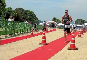  ??  ?? Palmerston North athlete David Martin crosses the line to win the Sagishima Triathlon in Mihara City, Japan.