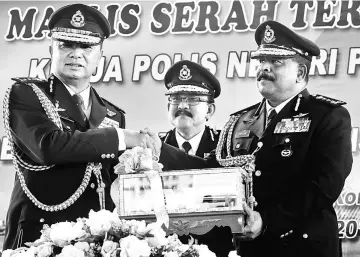  ?? — Bernama photo ?? Abdul Rahim (centre) witnessing the handover of duties between Chuah (left) and A Thaiveegan during the handover ceremony of the new police chief at state police headquarte­rs in George Town.