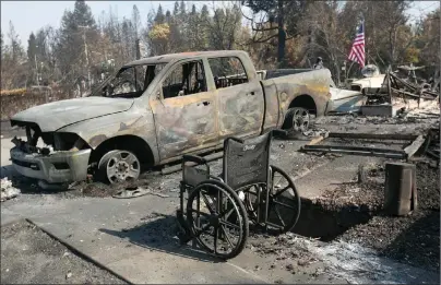  ?? AP PHOTO ?? A scorched truck and wheelchair sit outside the charred remains of a house in the Coffey Park area of Santa Rosa, Calif., Monday.